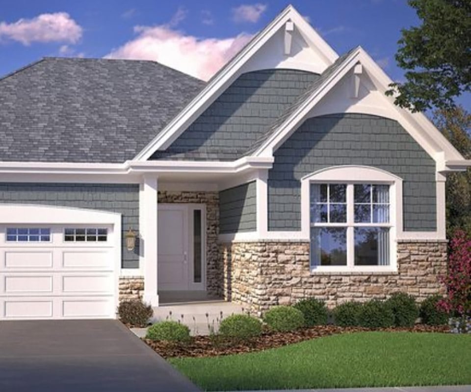 A beautiful house with gray siding, white trim, and excellent stonework. To get your own beautiful, durable siding, call today for a free vinyl siding cost estimate.